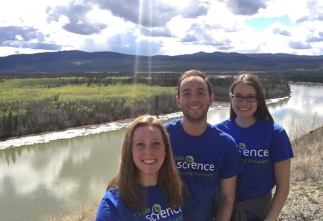 Ian Dimopoulos with other Let's Talk Science volunteers in front of a river and cloudy sky