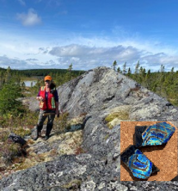 Nancy Rogers standing on a rocky outcrop with Labradorite mineral insert