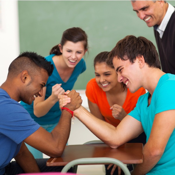 Teenage boys arm wrestling at school
