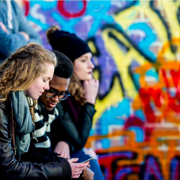 Teens near a graffiti wall