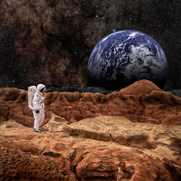 Astronaut standing on Mars with Earth in the background