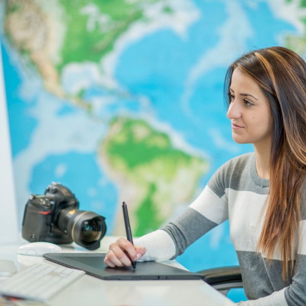 Woman working on computer in front of a map