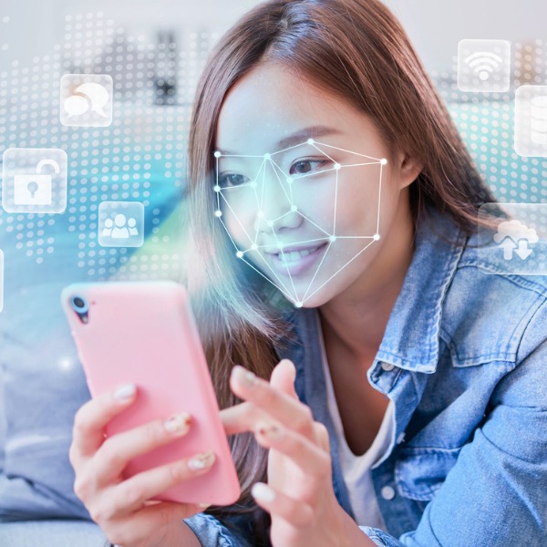Young woman and smart phone with facial recognition