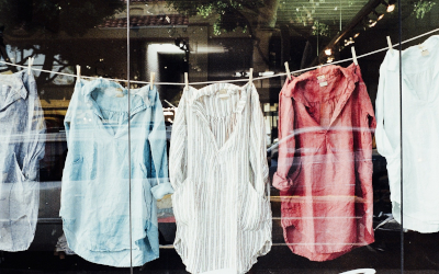 Clothes hung up to dry in front of a store window 
