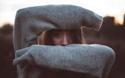 Woman partially hiding her face wearing a large sweater