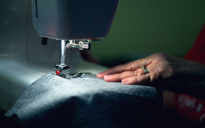 Hand guiding textiles into a sewing machine