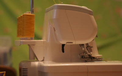 Thread spooled next to a sewing machine.