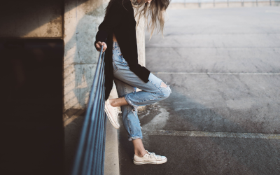 Woman in fast fashion jeans leaning up against a railing