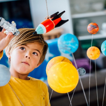 Child with model planets and rocket