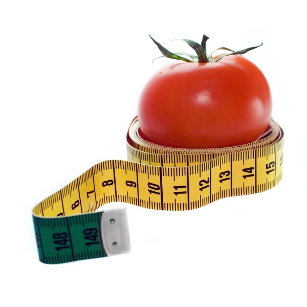 A measuring tape wrapped around a tomato
