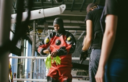 Marine Police Officer suits up in a scuba diving drysuit