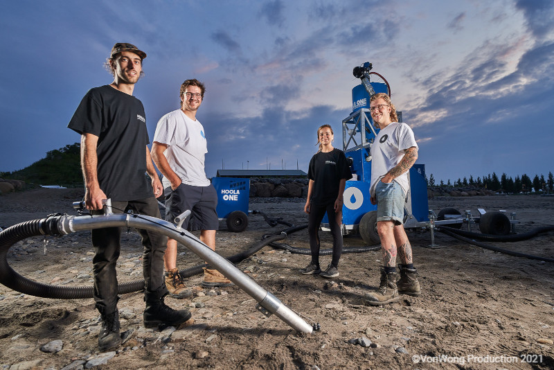 A group of students holding environmental cleanup equipment