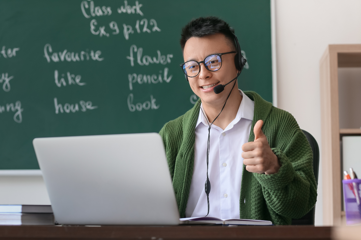 Teacher with thumbs up at laptop