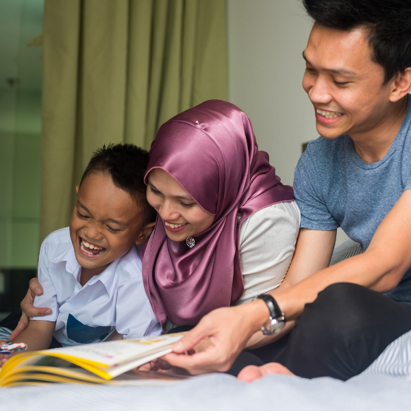 Family laughing and reading a book