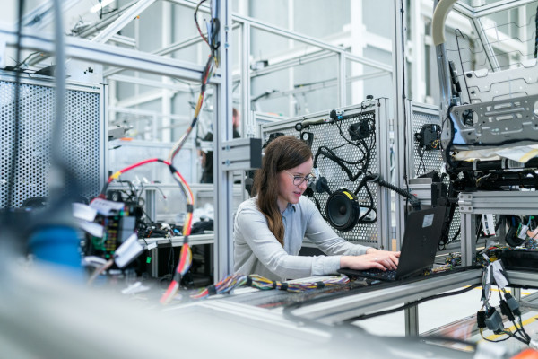 Female electronics engineer runs tests on laptop