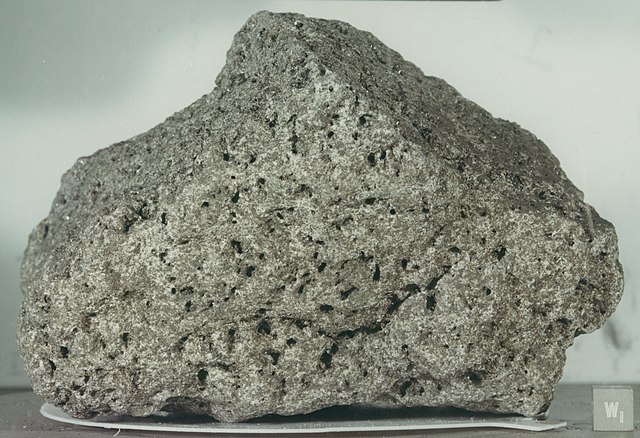 Shown is a colour photograph of pale greyish beige rock with a dimpled texture.