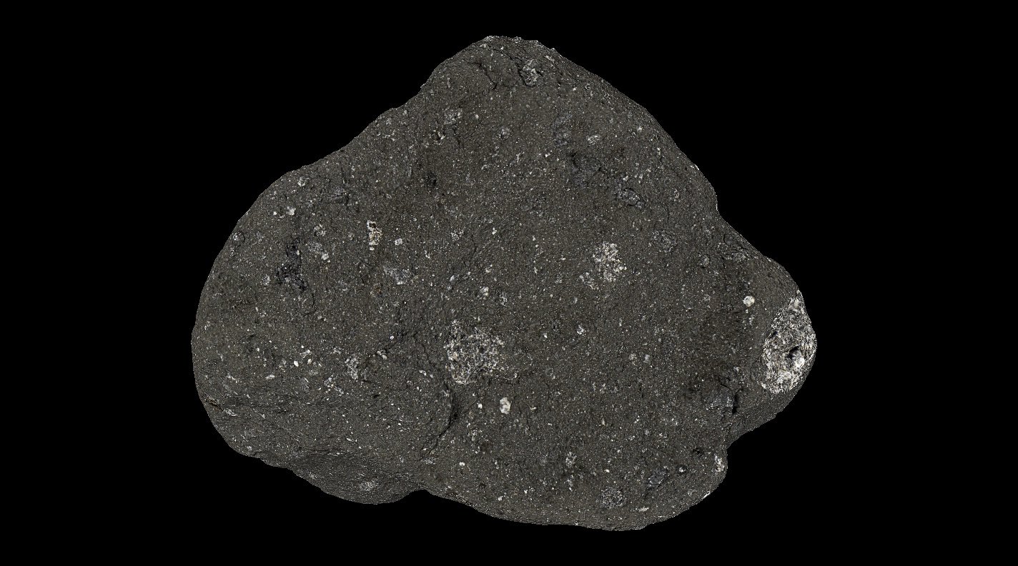Shown is a black and white photograph of a dark grey rock with a rough, grainy texture. 