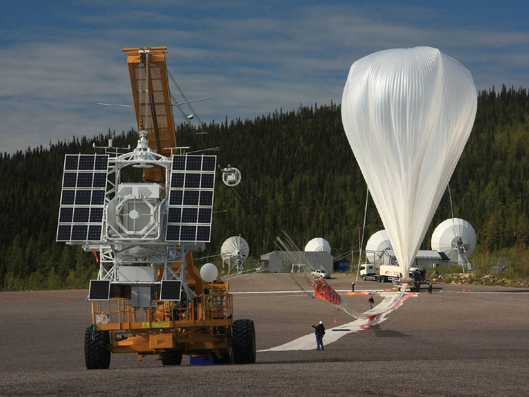 Shown is a colour photograph of a very large, white fabric balloon at the end of a runway.