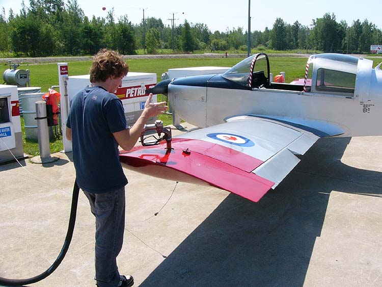 Shown is a colour photograph of a person refuelling a small aircraft