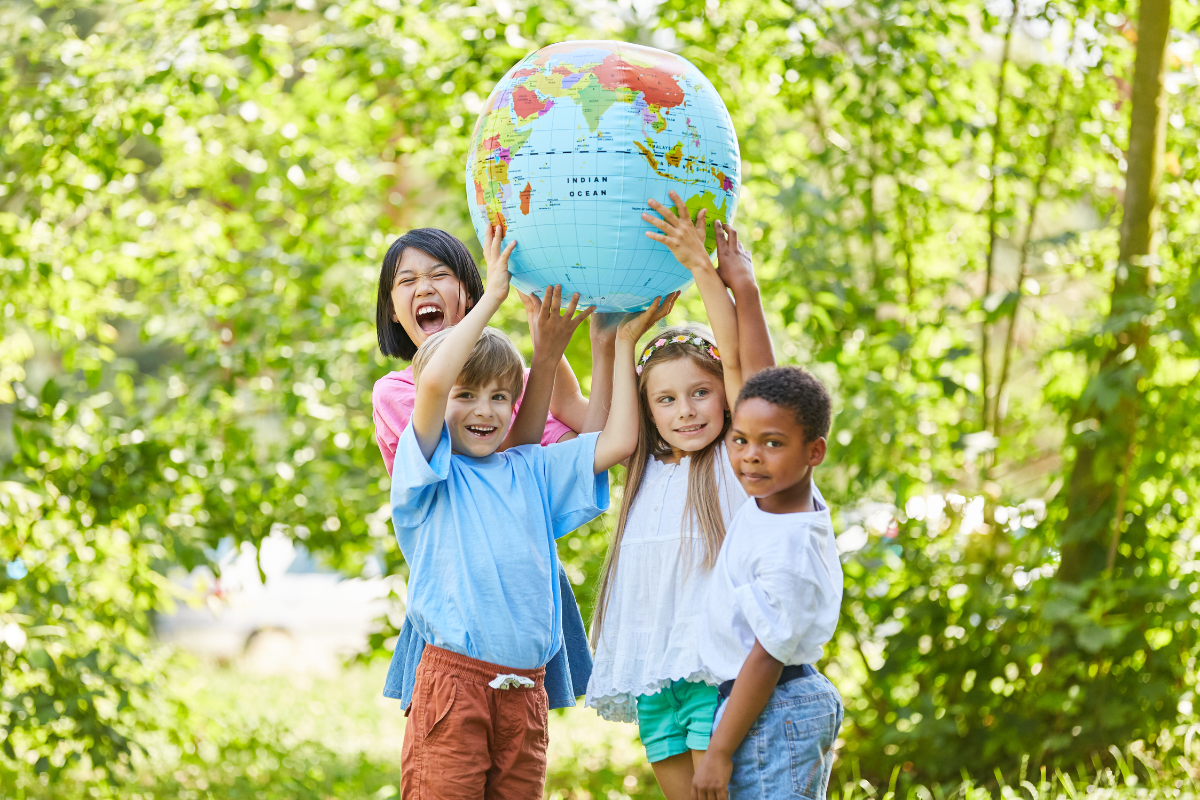 Children outside holding up globe