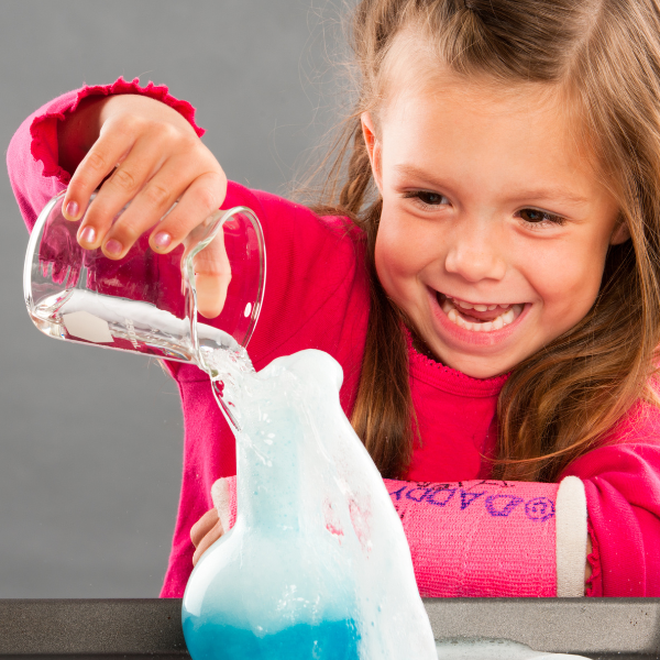Child smiling while performing science experiment
