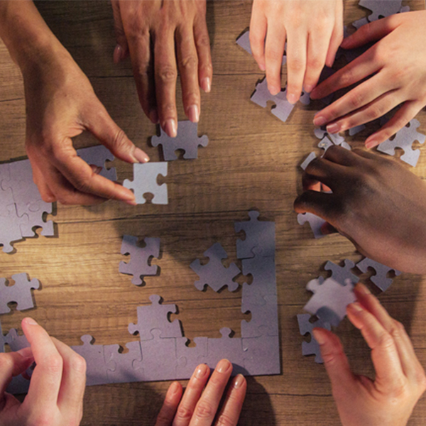 Hands assembling a jigsaw puzzle