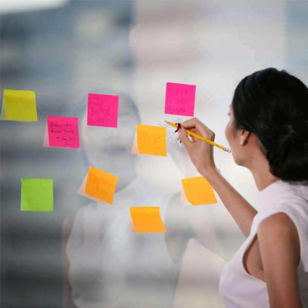 Image header for Card Sort learning strategy - woman checking over post it notes affixed to a glass wall