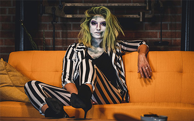 Woman in Beetlejuice costume on orange couch