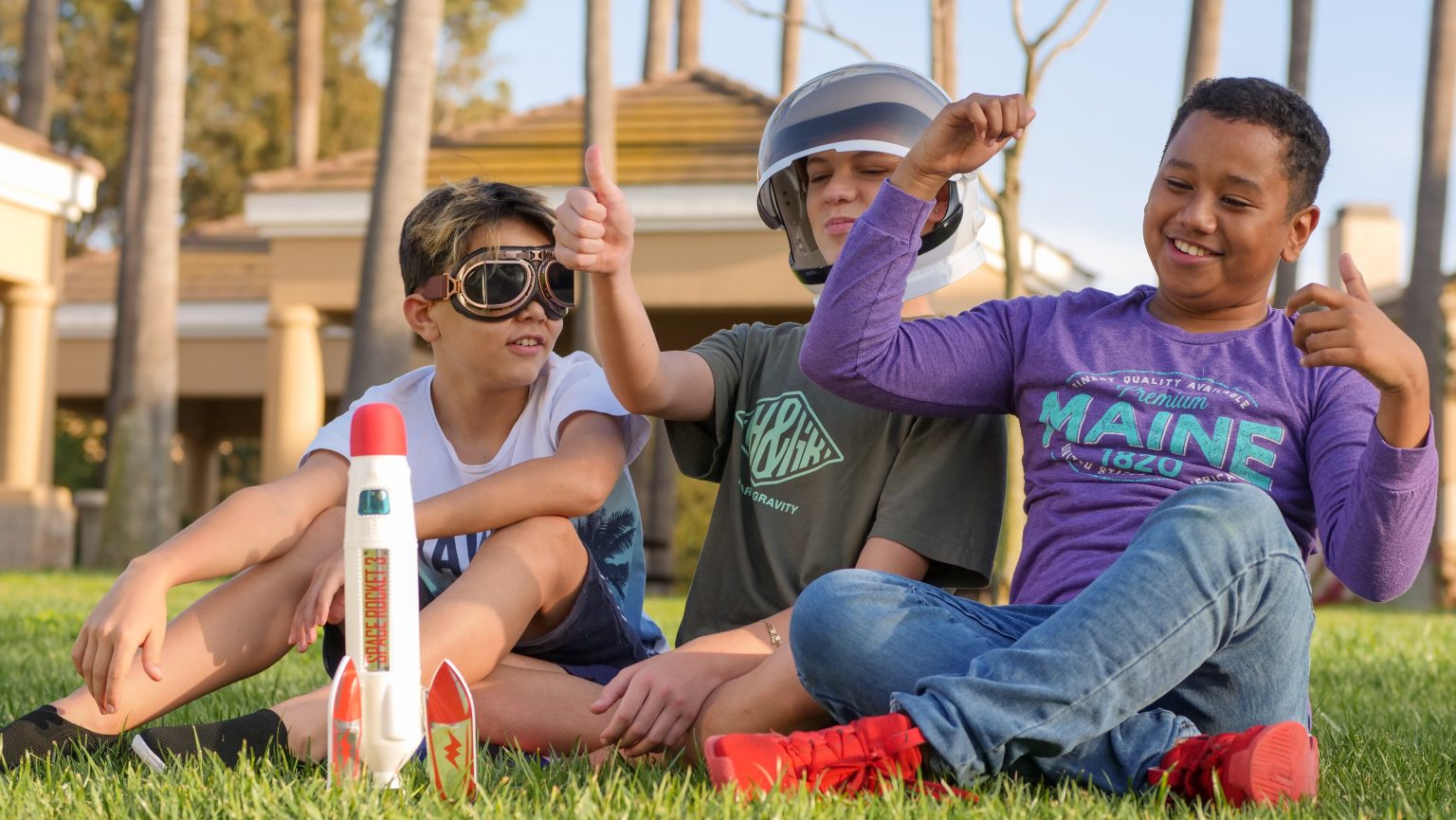 Kids doing a hands-on activity with a model rocket