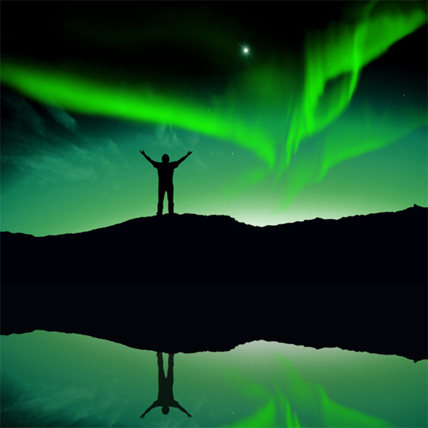 Silhouette of person in front of aurora