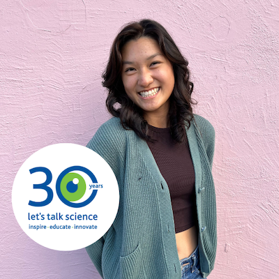 Caroline Huang smiling in front of a pink wall with the Let's Talk Science 30th Anniversary logo