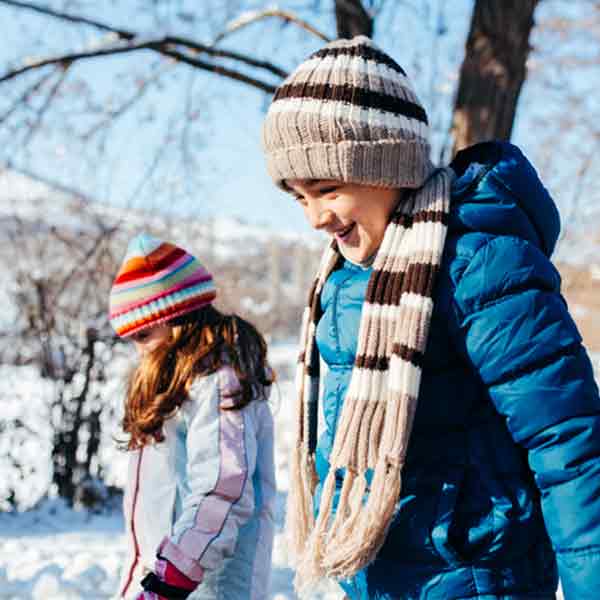 Two children walking outdoors in winter