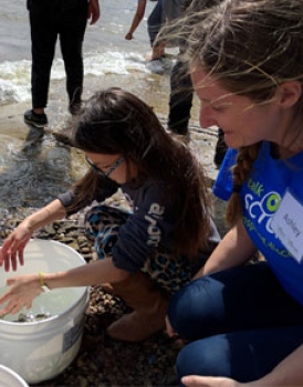 A student works with a Let’s Talk Science Outreach volunteer during a fish release activity