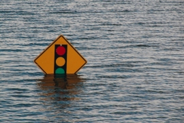 Flood water with traffic sign submerged.