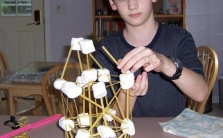 Student making structure with pasta and marshmallows