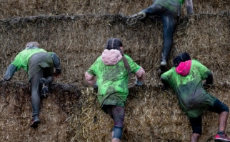 Children climbing a hill of hay bales