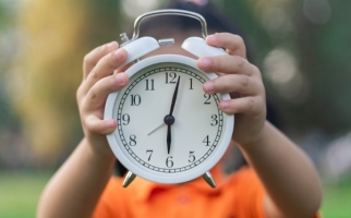 Child holding a clock 