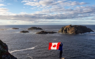 Woman with Canadian flag near the ocean