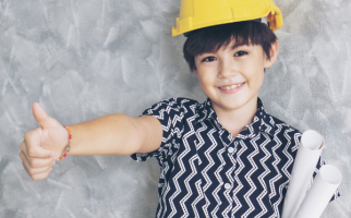 Child with hard hat with thumbs up gesture