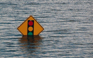 Flood water with traffic sign submerged.
