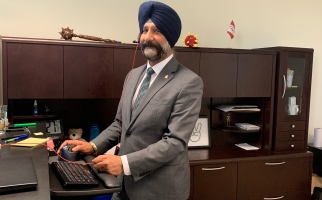 Dr. Harpreet Kochhar at standup computer station in his office.