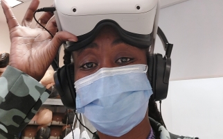 Karen Fleming at work, wearing mask and virtual reality goggles.