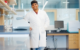 Mahesh Rachamalla in his lab wearing white lab coat 