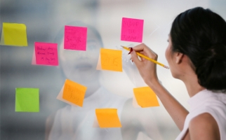 Image header for Card Sort learning strategy - woman checking over post it notes affixed to a glass wall