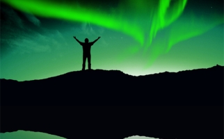 Silhouette of person in front of aurora