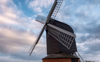 Image of a windmill with a cloudy sky in the background.
