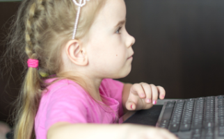 Small blonde girl looking at a computer