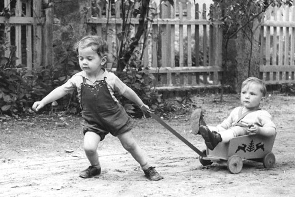 One child pulling a another child in a wagon 