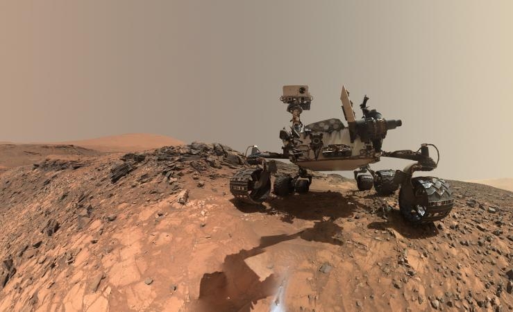 This picture shows the Curiosity rover and the barren rocky surface of Mars.