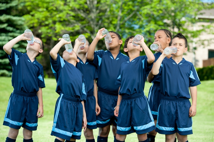 Children on a sports team drinking water